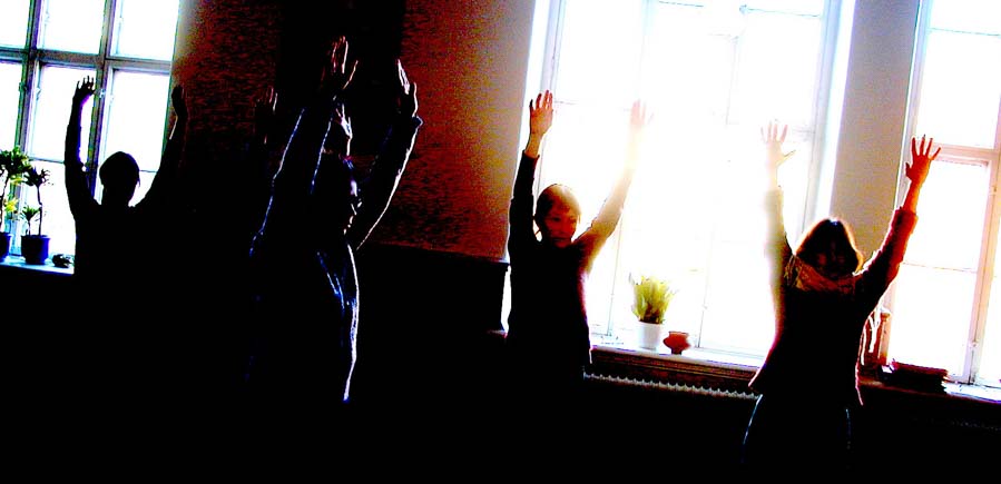 flera personer sträcker armarna i luften då de utövar Kum Nye yoga i Göteborg